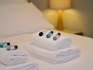 a pile of towels with pills on a bed at Stylish 3-Bed in Historic Caerleon-GardenParking Pass The Keys in Newport +102 photos