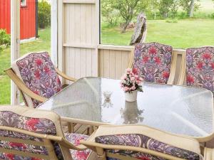 a table with chairs and a vase of flowers on a porch at 4 star holiday home in Vara in Vara