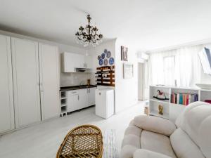 a white living room with a white couch and a chandelier at Erendiz Garden Hotel in Kemer