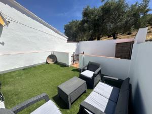 a small backyard with chairs and a lawn at Casa Cerro Luna Con Chimenea in Constantina