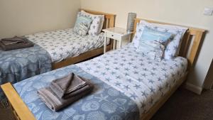 a room with two beds and a night stand at Lot 1 The Old Auction Room in Whitby