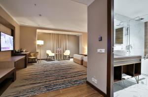 a hotel room with a bed and a bathroom at Zarafshon Hotel Bukhara in Bukhara
