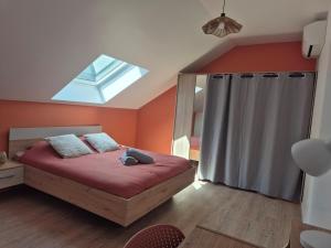 a bedroom with a bed and a skylight at La bulle colorée in Saint-Aubin-lès-Elbeuf