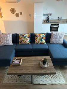 a blue couch in a living room with a coffee table at La bulle colorée in Saint-Aubin-lès-Elbeuf +29 photos
