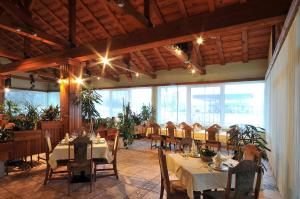 een restaurant met tafels en stoelen en grote ramen bij Motel Kod Bakija in Karlovac
