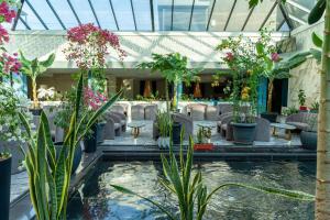 a lobby with a lot of plants and a pond at Zarafshon Hotel Bukhara in Bukhara