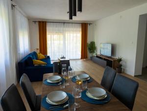 a living room with a table with plates and wine glasses at OPG Murgić in Perušić