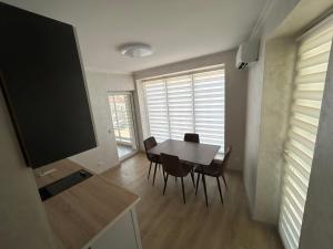 a dining room with a table and chairs and a television at Piccolo Mondo in Chişinău +2 photos