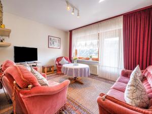 a living room with two chairs and a tv at Geräumiges Apartment am Waldrand im Sauerland in Medebach