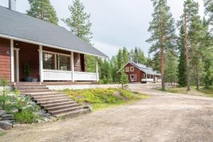una casa con un camino de tierra al lado de un edificio en Villa Sinirinta, Ounasvaara, en Rovaniemi 11 fotos más
