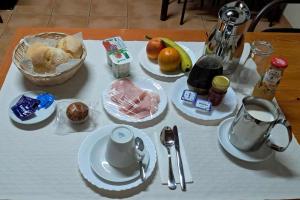 a table with plates and utensils on a table at Quarto Familiar do Januário in Bilhó