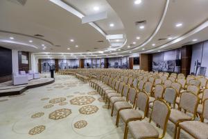 a large room with rows of chairs and a stage at Zarafshon Hotel Bukhara in Bukhara +46 photos