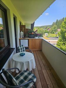 a porch with a table and chairs on a balcony at Appartement Kopp am Kirnberg See in Unterbränd