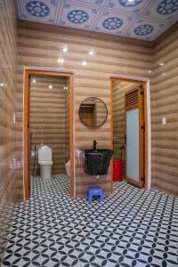 un bagno con un water e una porta con un pavimento piastrellato di Khách Sạn Tây Ninh LaNa a Tây Ninh