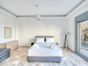 a bedroom with a bed and a large window at Diōni by the Beach in Kardamaina