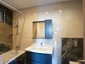 a bathroom with a sink and a mirror and a shower at Diōni by the Beach in Kardamaina