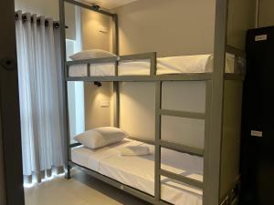 a room with a bunk bed with white pillows at Candea Cocoon Kandy in Kandy