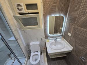 a bathroom with a sink and a toilet and a mirror at Sea Apartment -Families Only in Alexandria +50 photos