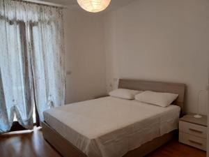 a bedroom with a bed and a window with curtains at Casa Kalos in Monteprandone