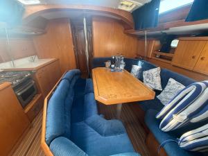 a dining room with a table and blue couches at Hope Boat 42 Limanu in Limanu