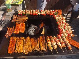 a grill with many different types of food on it at Pensiunea Vladut Timisoara in Timişoara