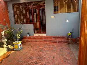 an open door of a house with a brick floor at Thillai Natarajar Nivas - Family Stay in Chidambaram +5 photos