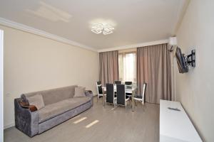 a living room with a couch and a table with chairs at apartment in a small center near a park in Yerevan