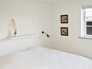 een witte slaapkamer met een bed en een lamp bij 10 person holiday home in Nysted-By Traum in Nysted