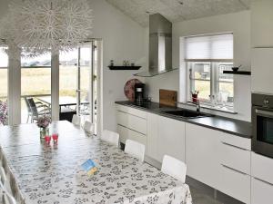 a kitchen with a table and a dining room at 5 star holiday home in Nysted in Nysted
