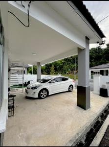 a white car parked inside of a garage at Aura Homestay in Sungai Petani