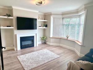 a living room with a fireplace and a flat screen tv at Recently renovated 3 bed home in Southampton +6 photos