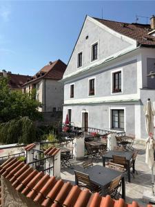 a white building with tables and chairs in front of it at Hotel Barbakan in Český Krumlov