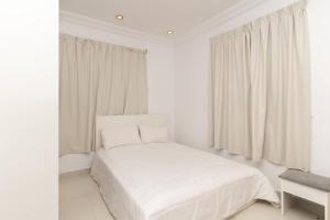 a white bedroom with a white bed and a window at شقة الصواري الفاخرة in Jeddah