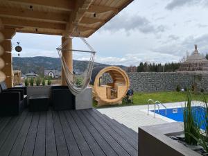 a patio with a hammock and a swimming pool at Chata pod Groniem in Skawica
