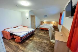 a hotel room with two beds and a television at Ski Lodge Pampeago in Tesero