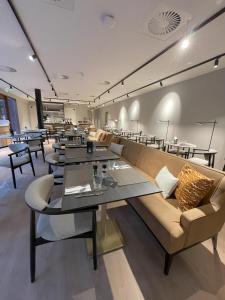 a restaurant with long tables and couches and chairs at Hotel Maison Maastricht Centrum - Handwritten Collection in Maastricht