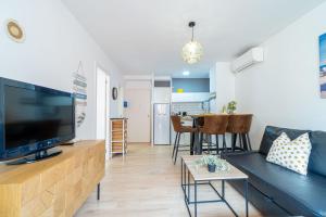 a living room with a large flat screen tv at 1002 Precioso apartamento a 250 m de la playa by homeselectspain in Empuriabrava