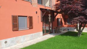 a building with a window and a grass yard at Cascina Tetto Cavallo Monolocale Rustico in Revello +9 photos