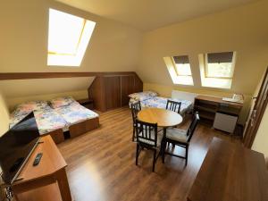 a room with two beds and a table and a desk at Babie Lato in Włodarka