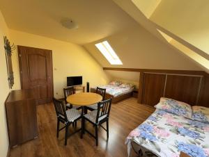 a room with two beds and a table and chairs at Babie Lato in Włodarka