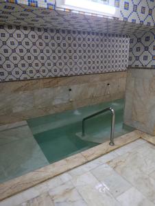 a pool of water in a bathroom with a bath tub at uç su havuzlu termal in Kızılcahamam
