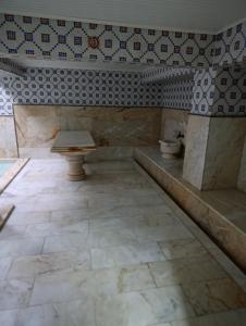 a bathroom with a bench and a tiled wall at uç su havuzlu termal in Kızılcahamam