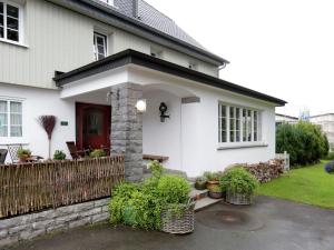a white house with a red door and a fence at Winterberg Gruppenhaus mit Sauna ideal für Familien & Freunde in Winterberg