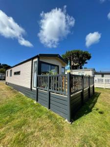 a mobile home with a porch and a fence at Serenity in Saint Erth
