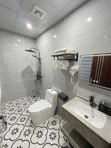 a bathroom with a toilet and a sink at Royal Hotel in Móng Cái