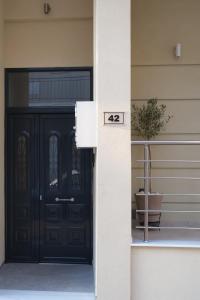 een zwarte deur van een huis met een potplant bij Olivia 42 in Nafpaktos