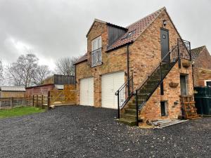 a brick house with a staircase on the side of it at Roseberry View Barn, Northallerton in Northallerton
