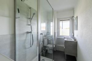 a bathroom with a shower and a toilet and a sink at Saint-Louis Centre, Logement idéal voyageurs in Saint-Louis