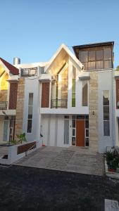 a large white house with a courtyard in front of it at Serene Villa in Batu with 3 Bedrooms and a Rooftop in Batu +4 photos