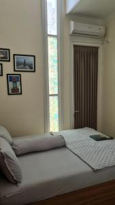 a large bed in a bedroom with a window at Serene Villa in Batu with 3 Bedrooms and a Rooftop in Batu